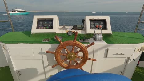 Steering-Wheel-and-Navigation-Compass-on-a-Yacht-Background-of-Red-Sea