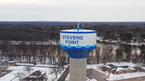 Aerial,-water-tank-tower-in-Stevens-Point,-Wisconsin-during-winter-season