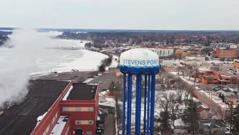 Aerial,-water-tower-in-Stevens-Point-Wisconsin-during-winter-day