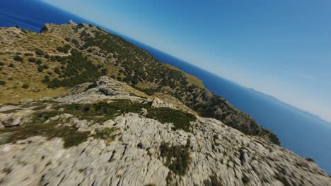Fpv-Drone-Volando-Sobre-Mountain-Peek-Buceando-Colina-Abajo-Y-Volando-De-Cerca-Sobre-Las-Cabezas-De-Cabras-Montesas-En-Mallorca