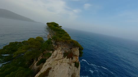 FPV-Drone-flying-over-Mallorca-Coast-Line-following-two-seagulls-closely-and-diving-down-the-cliff-flying-over-the-ocean-waves