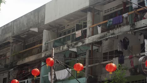 Pan-shot-decaying-balconies-from-a-poor-residential-neighborhood-decorated-with-red-paper-lanterns