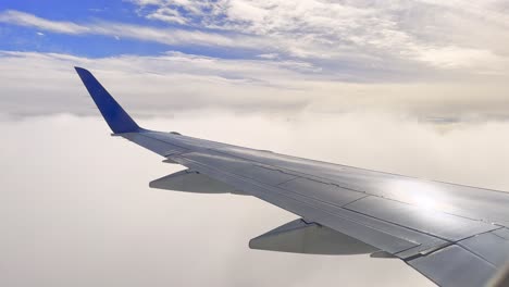 Toma-Estática-De-La-Vista-De-La-Ventana-Del-Avión-Que-Muestra-El-Ala-Brillante-Y-Las-Nubes-Durante-La-Aproximación-Al-Aterrizaje