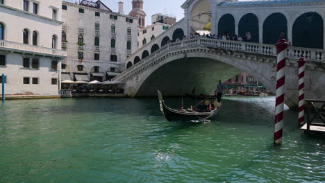 Gondolas-Sailing-Across-Rialto-Bridge-In-The-Old-Town-Of-Venice,-Italy