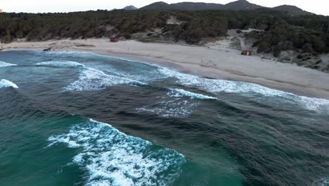 Waves-crashing-onto-beach-Cala-Aguila-in-Mallorca-Cala-Rajada-in-late-evening-sun