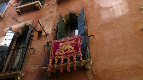 Flag-Of-The-Republic-Of-Venice-Hanging-On-The-Balcony-In-The-Old-Town-Of-Venice,-Italy