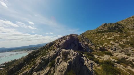 FPV-Drone-flying-low-over-rocky-hills-in-Mallorca
