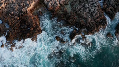 Crashing-waves-onto-rocky-shoreline-in-Mallorca-island-at-golden-hour