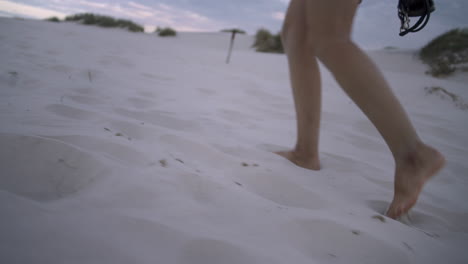 Woman-walks-barefoot-on-a-white-sand-dune