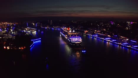 Queen-Mary-2-Kreuzfahrtschiff-Im-Hamburger-Hafen-An-Kreuzfahrttagen-In-Der-Nacht-Zur-Blauen-Stunde-Mit-Blauer-Lichtshow-über-Der-Hamburger-City