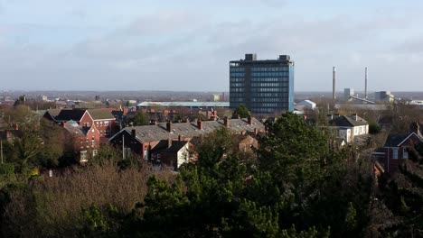 Luftaufnahme-über-Parkbäume-Zum-Industriestadtbild-Mit-Blauer-Wolkenkratzerskyline,-Merseyside,-England