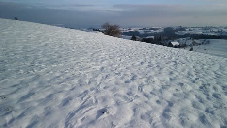 Drohne-Fliegt-über-Eine-Winterliche,-Hügelige-Landschaft-In-Der-Ländlichen-Schweiz