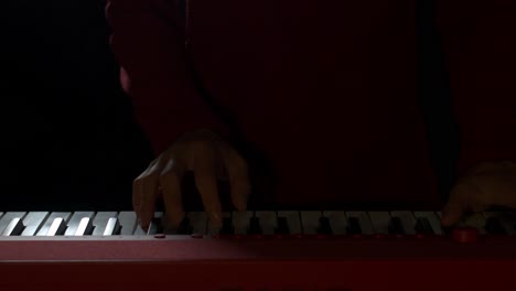 Toma-Cenital-De-Las-Manos-De-Un-Hábil-Pianista-Tocando-Un-Piano-Eléctrico-Rojo