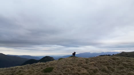 Drone-shot-of-a-dog-jumping-in-the-arms-of-the-owner-on-a-mountain-range
