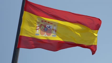 Bandera-Nacional-De-España-En-Un-Viento-Sobre-Fondo-De-Cielo-Azul,-Verano-Soleado