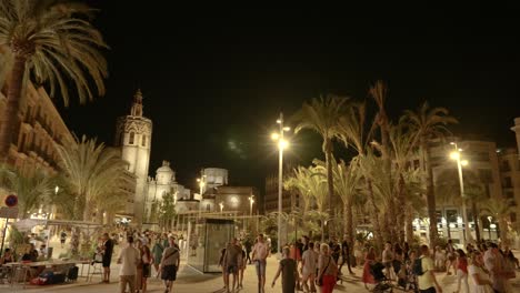 Wide-angle-view-of-Main-Reina-square-in-Valencia-historic-old-town,-full-of-tourists-at-summer-night,-Spain