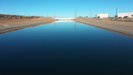 slow-aerial-dolly-tilt-of-an-aqueduct-in-hesperia-california-on-a-blue-bird-day-in-the-morning