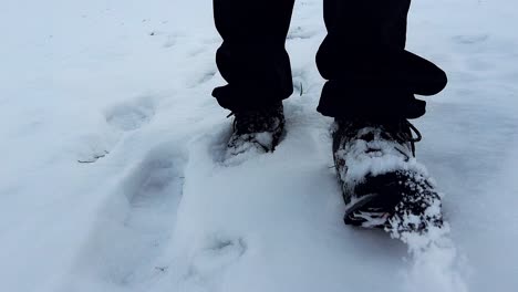 Primer-Plano-De-Los-Pies-De-Un-Excursionista-Masculino-Caminando-A-Través-De-La-Nieve-En-Polvo