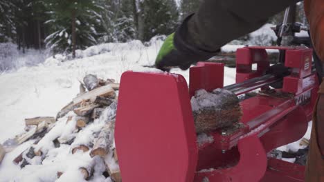 Winterwald-Mit-Einer-Person,-Die-Eine-Holzspaltmaschine-Benutzt