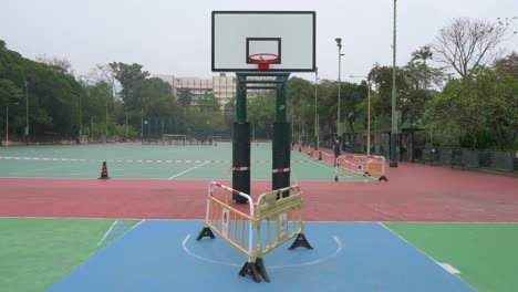Ein-Leerer-Basketballplatz-Ist-Auf-Einem-Geschlossenen-Spielplatz-Aufgrund-Des-Ausbruchs-Des-Covid-19-coronavirus-Und-Der-Einschränkungen-In-Hongkong-Zu-Sehen