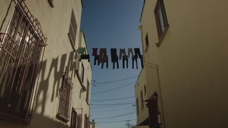 low-angle-wide-static-shot-of-clothes-hanging-on-a-wire-outside-to-dry-in-the-California-sun