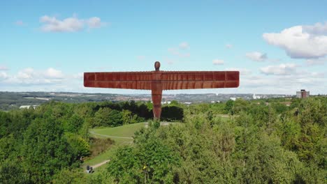 Drone-Volando-Sobre-Los-árboles-Hacia-El-ángel-Del-Norte-En-Gateshead-Cerca-De-Newcastle-Inglaterra