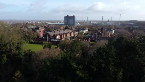 Luftaufnahme-über-Parkbäume-Zum-Industriellen-Stadtbild-Mit-Pilkingtons-Blue-Skyscraper,-Merseyside,-England