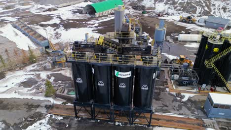 Rotating-around-the-large-black-silos-is-an-aerial-drone-viewpoint-of-the-at-the-Calgary-Lafarge-cement-plant-and-surrounding-area