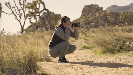 Chica-Fotografiando-El-Parque-Nacional-Joshua-Tree-Desert-California-Con-Una-Cámara-Sony-A1---ángulo-Bajo