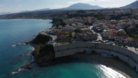 Aerial-View-Over-Cala-Petrolo-Beach-With-Towering-Walls-In-Castellammare-Del-Golfo