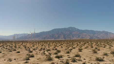 Palm-Springs-Drone-of-Windmills-at-the-Mountains-footstep-with-desert-and-cacti-in-foreground-wide-view