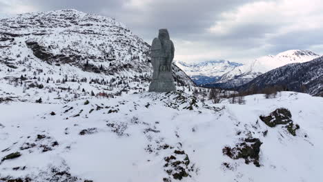 Adler-Skulptur-Aus-Stein-Am-Simplonpass,-Im-Hintergrund-Die-Schneebedeckten-Hochalpen