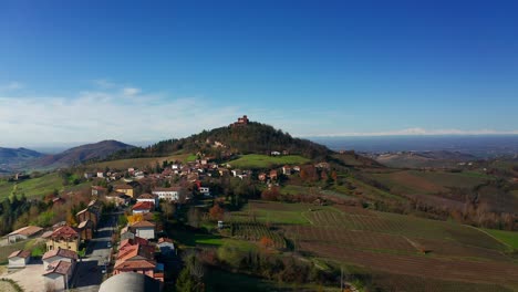 Aerial-View-Of-Local-Village-Town-With-View-Of-Castle-of-Montalto-Pavese-On-Hilltop-In-Background-In-Lombardy-Italy