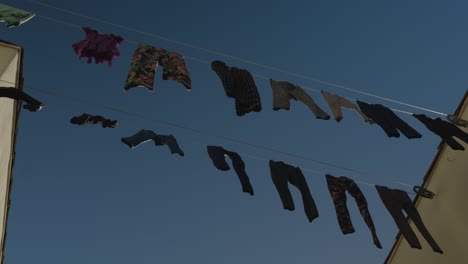 low-angle-rotating-shot-of-clothes-hanging-on-a-wire-outside-to-dry-in-the-California-sun