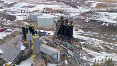 Rotating-around-the-black-silos-is-an-aerial-drone-viewpoint-of-the-at-the-Calgary-Lafarge-cement-plant-and-surrounding-area