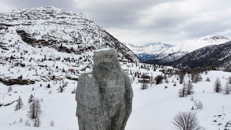 águila-Escultura-De-Piedra-En-El-Paso-De-Simplon-Con-En-El-Fondo-Los-Altos-Alpes-Suizos-Cubiertos-De-Nieve