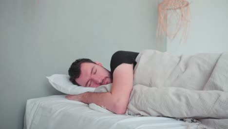Sleeping-man,-caucasian-white-with-beard,-young-man-lying-in-bed-sleeping-dreaming,-uncomfortable-pillow,-turn-over-in-sleep