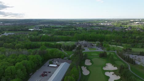 Golf-pitch-in-Aurora,-Ontario,-Canada-in-may,-panorama-on-the-city-from-a-drone,-Drone-flying-backwards