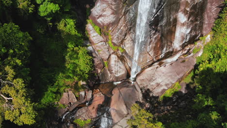 Descending-drone-footage-of-a-beautiful-waterfall-in-Langkawi,-Malaysia