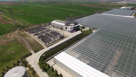 Rotate-and-move-away-from-the-power-plant,-the-moving-away-reveals-a-large-greenhouse