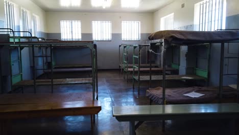 A-follow-shot-exploring-a-group-cell-at-Robben-Island-prison-in-Cape-Town,-South-Africa