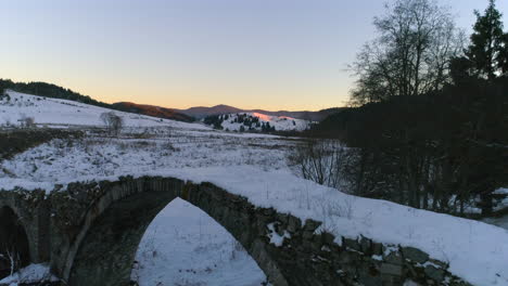 Puente-De-Piedra-Cubierto-De-Nieve-Temprano-En-La-Mañana