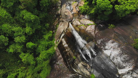 Blick-Von-Oben-Nach-Unten-Von-Einer-Drohne-Auf-Den-Wasserfall-Mit-Sieben-Brunnen,-Tauchbecken,-Wasserfalllak,-Felsen,-Bäume