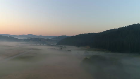 Am-Frühen-Morgen-über-Ein-Hügeliges-Nebelfeld-Fliegen
