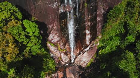 Descending-drone-flies-closer-to-the-water-falling-from,-shot-at-at-the-Seven-Wells-Waterfall-in-Malaysia
