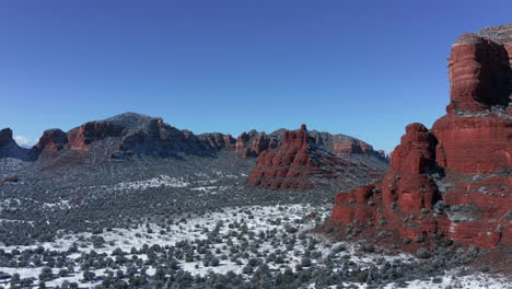 Aerial-Pan-of-Bell-Rock-and-Courthouse-Butte,-Village-of-Oak-Creek,-Sedona-Arizona---After-a-snowfall