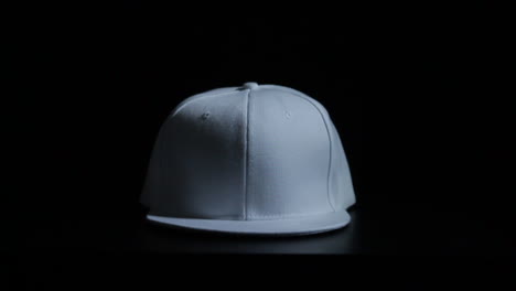 Weißer-Snapback-Hut,-Bedeckt-Mit-Tropfender-Schwarzer-Farbe-Mit-Schwarzem-Unendlichkeitshintergrund