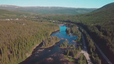 Crane-up-while-panning-drone-shot-over-a-river-in-a-large-forest-in-mid-Norway
