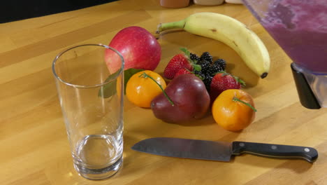 Pouring-fruit-smoothie-into-glass-from-blender