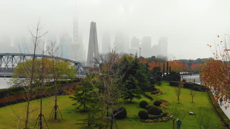 Drohne,-Die-Das-Denkmal-Für-Die-Helden-Des-Volkes-Und-Die-Sehr-Neblige-Skyline-Von-Shanghai-Enthüllt